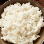 Close-up of a bowl of fluffy, glossy sushi rice ready for rolling or serving.
