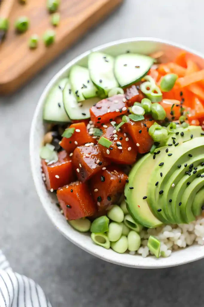 Ahi tuna poke bowl with avocado, cucumber, edamame, and sesame seeds over rice