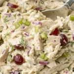 Bowl of creamy chicken salad with grapes, celery, dill, and red onion
