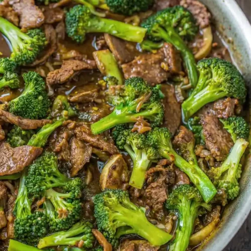 Beef and broccoli stir fry in a pan with tender beef strips and bright green broccoli in a glossy sauce.