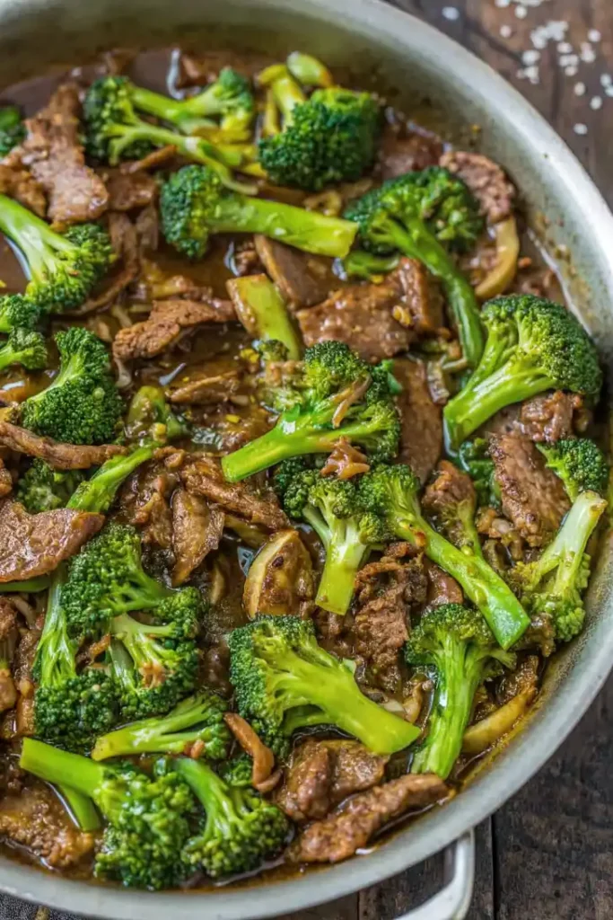 Beef and broccoli stir fry in a pan with tender beef strips and bright green broccoli in a glossy sauce.