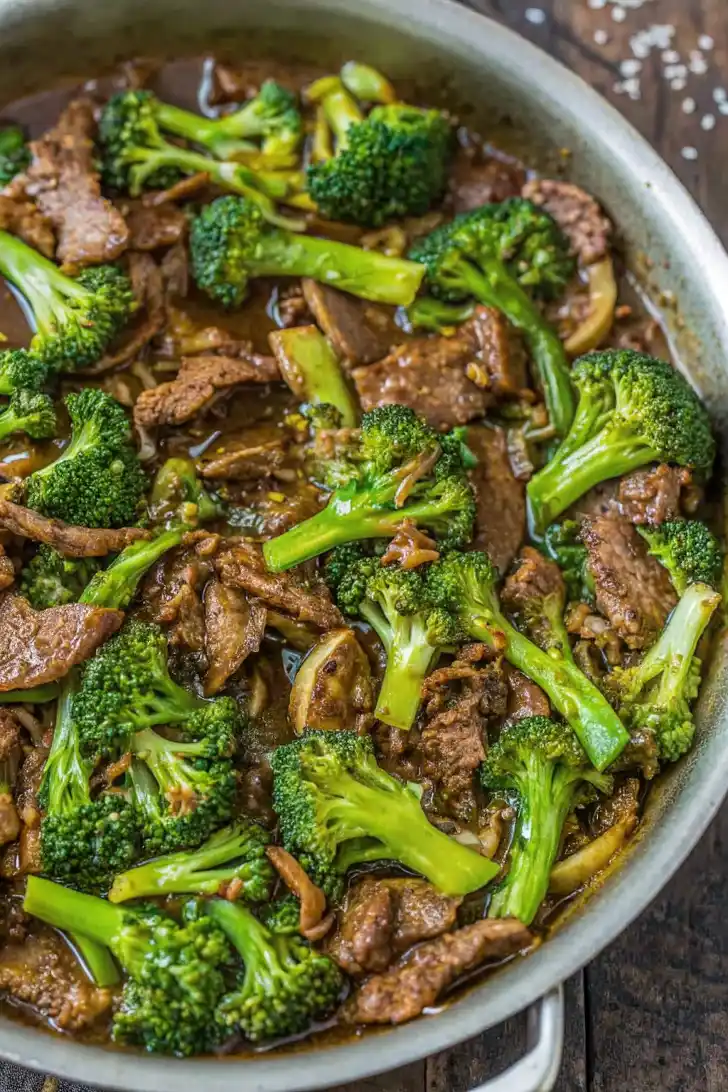 Beef and broccoli stir fry in a pan with tender beef strips and bright green broccoli in a glossy sauce.