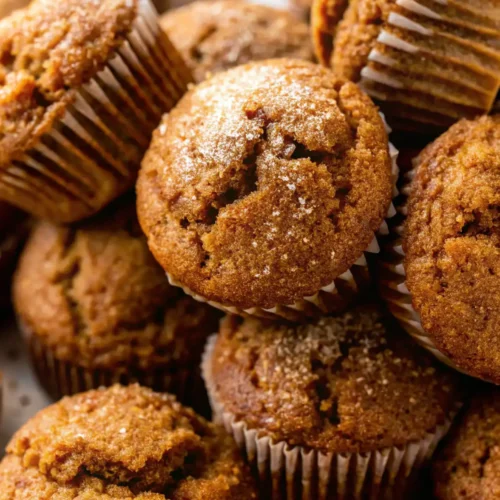 Close-up of homemade pumpkin muffins with cracked tops and a sprinkle of sugar