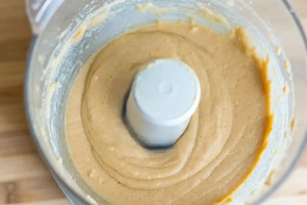 Blended hummus in a food processor with a smooth and creamy texture