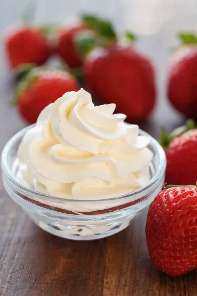 Chantilly cream swirl in glass bowl with fresh strawberries