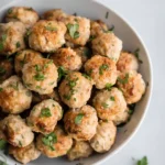 Easy baked turkey meatballs in a white bowl garnished with fresh parsley