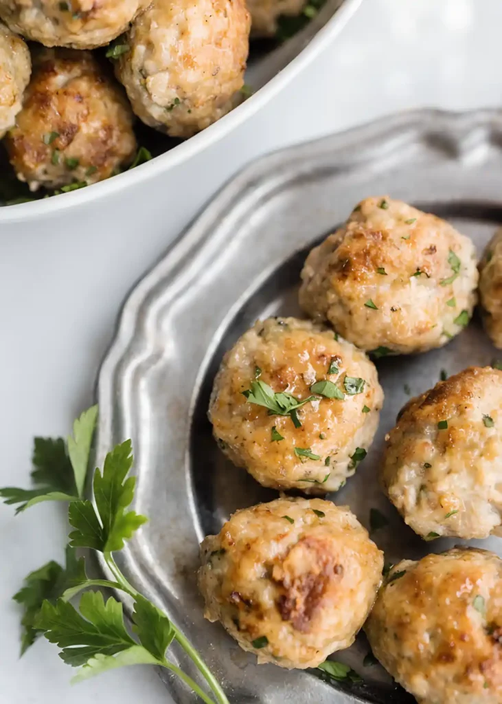 Ground turkey meatballs on a silver tray garnished with fresh parsley