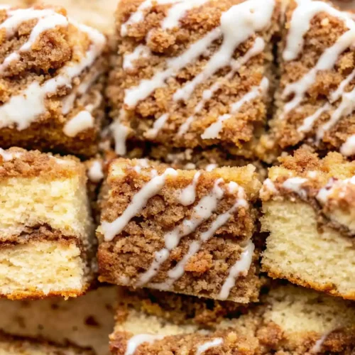 Moist cinnamon coffee cake squares with crumb topping and vanilla glaze
