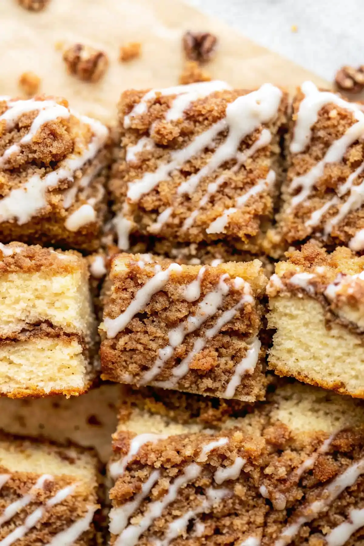 Moist cinnamon coffee cake squares with crumb topping and vanilla glaze