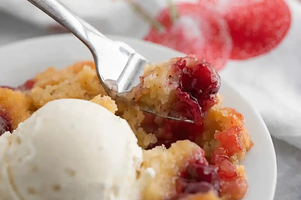 4 ingredient dump cake recipe with cherry filling and vanilla ice cream on fork
