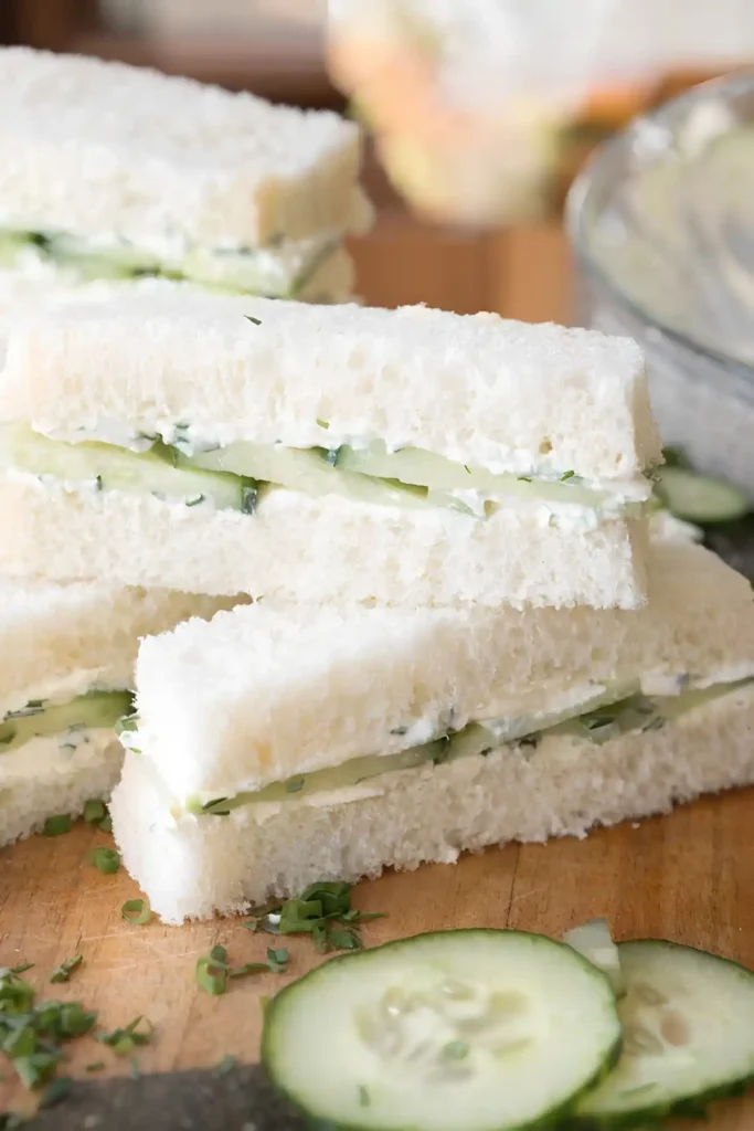 Cucumber tea sandwiches with creamy herb spread and thin cucumber slices on soft crustless white bread.