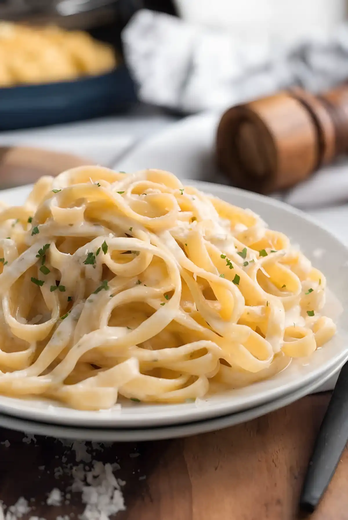 Creamy Fettuccine Alfredo pasta served on a white plate with parmesan and parsley garnish