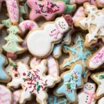 Decorated sugar cookies with royal icing in snowflake, snowman, and Christmas shapes with colorful sprinkles