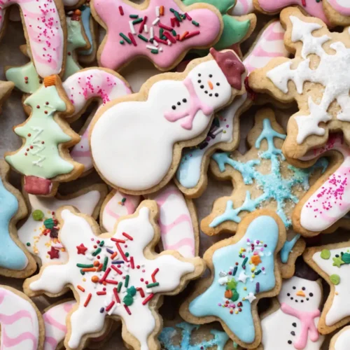 Decorated sugar cookies with royal icing in snowflake, snowman, and Christmas shapes with colorful sprinkles