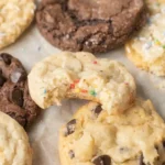 Soft cake mix cookies with chocolate chips and funfetti sprinkles on parchment paper, including a broken cookie showing a chewy center.