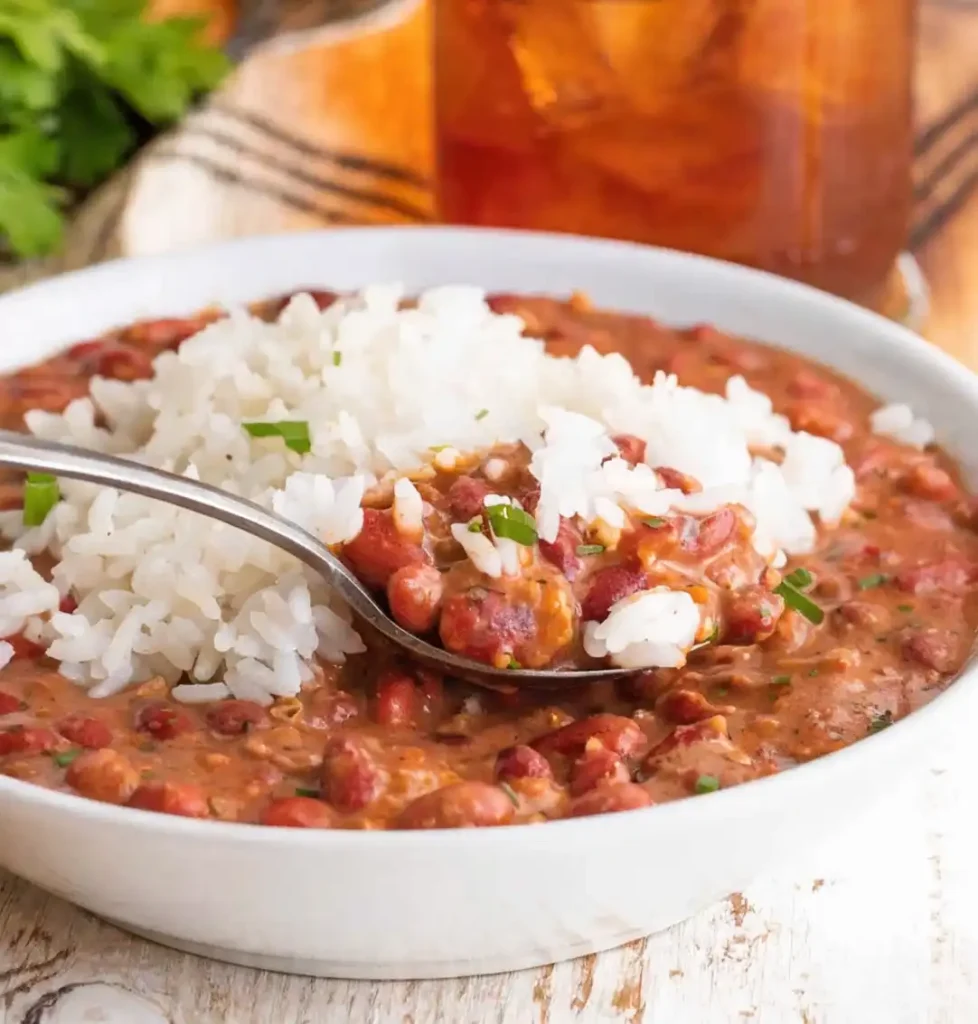 creamy red beans and rice recipe with white rice and spoon showing thick rich bean texture