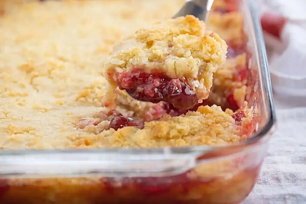 simple dump cake dessert with cherry filling and golden crust in baking dish