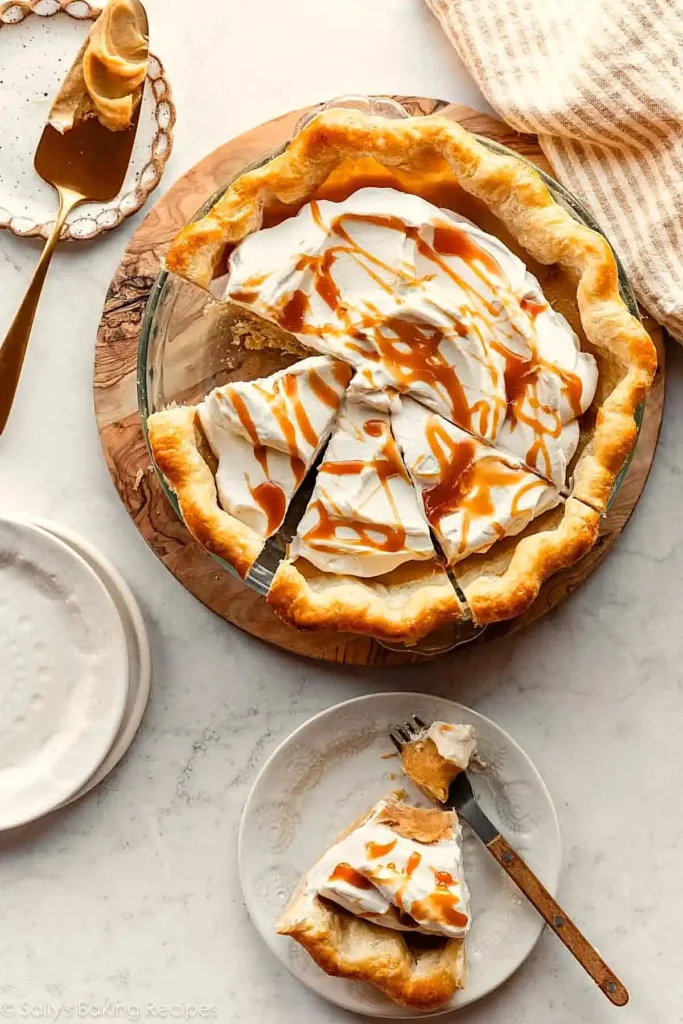 Caramel pie topped with whipped cream and caramel drizzle served in slices on a plate