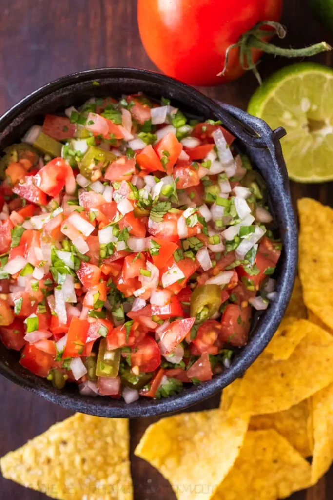 Authentic pico de gallo in a bowl with tomatoes onion cilantro and jalapeño served with tortilla chips