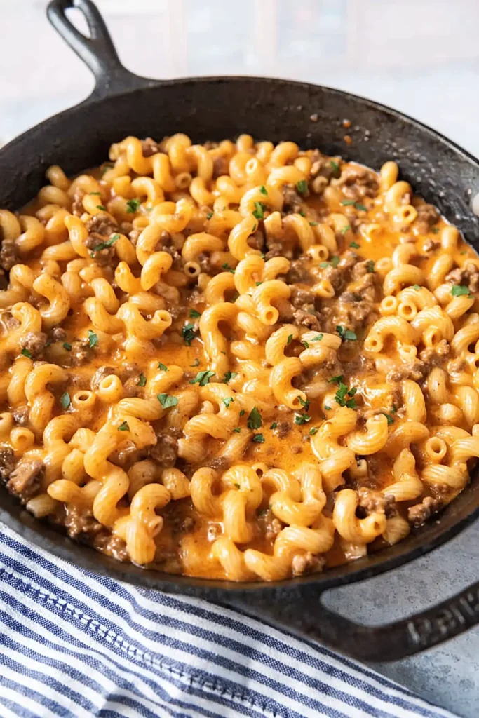 Easy homemade hamburger helper in cast iron skillet with creamy cheese sauce ground beef and macaroni