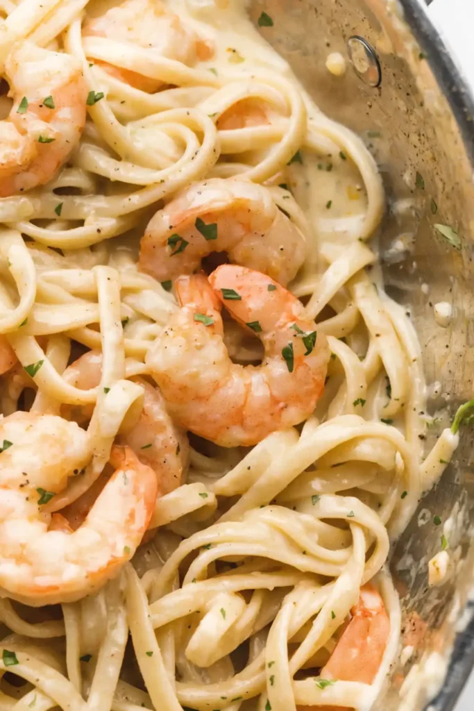 Close-up creamy shrimp pasta with linguine, garlic sauce, and tender shrimp in a skillet