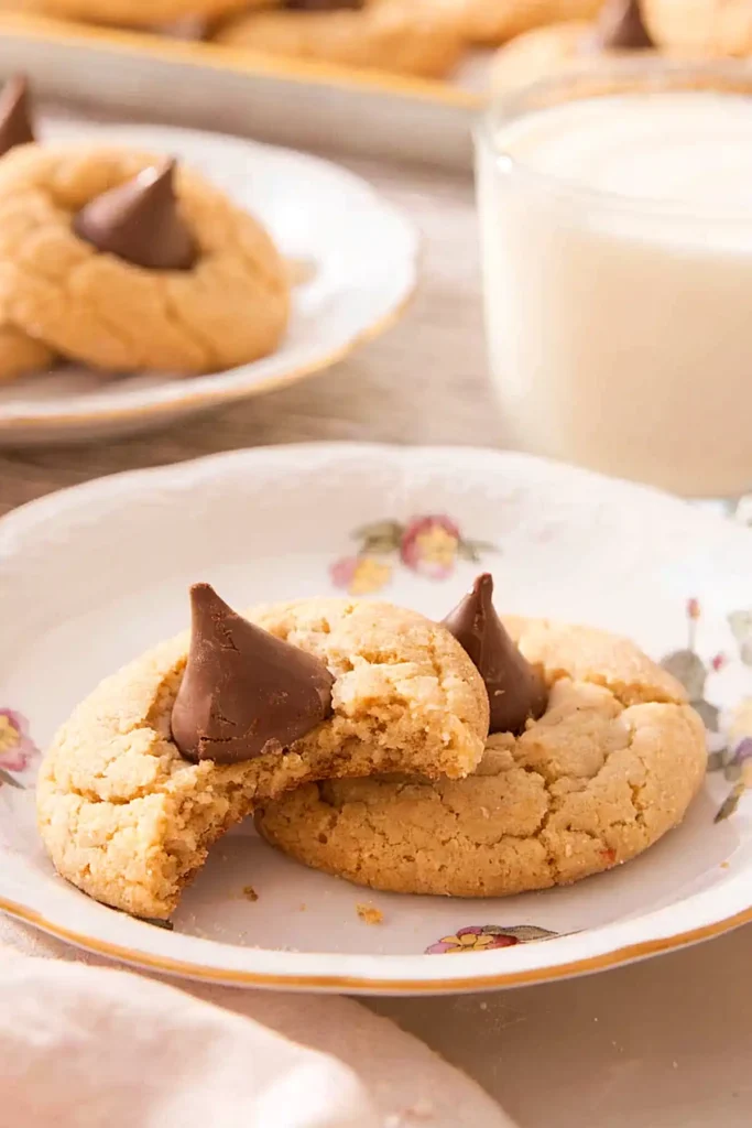 Soft peanut butter blossom cookies with chocolate kisses and a broken cookie showing inside